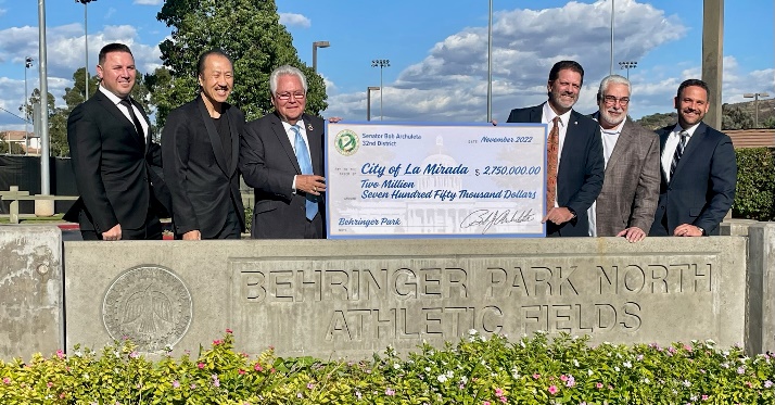 Senator next to a large check with the public